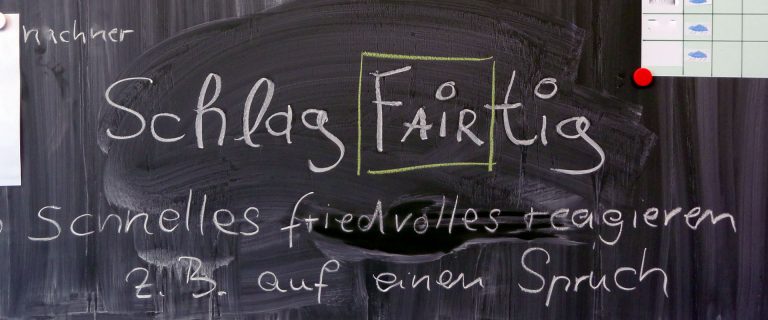 Tafel mit Schrift "SchlagFAIRtig" und anderer Schrift